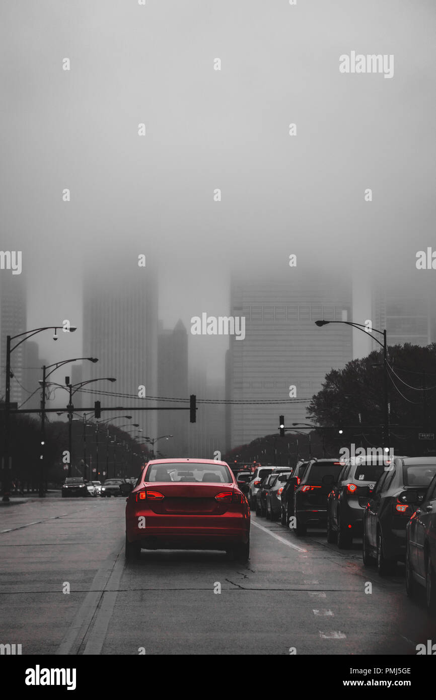 Cars driving downtown verso grattacieli nella nebbia, Chicago, Illinois, Stati Uniti Foto Stock