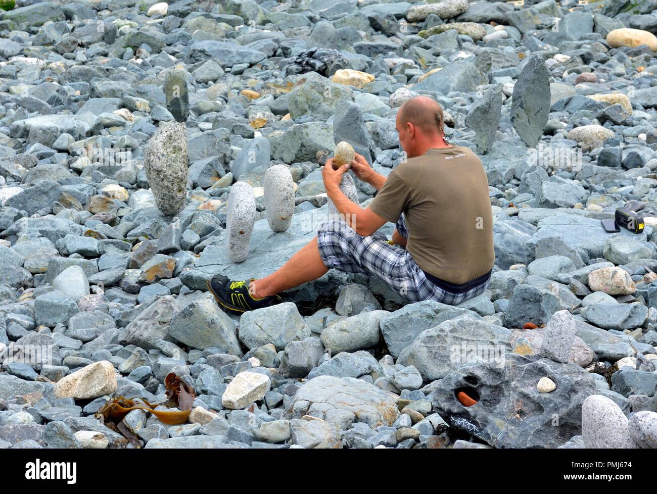 Un uomo pietre di bilanciamento,rocce,ciottoli,St Ives beach,Cornwall,l'Inghilterra,UK Foto Stock
