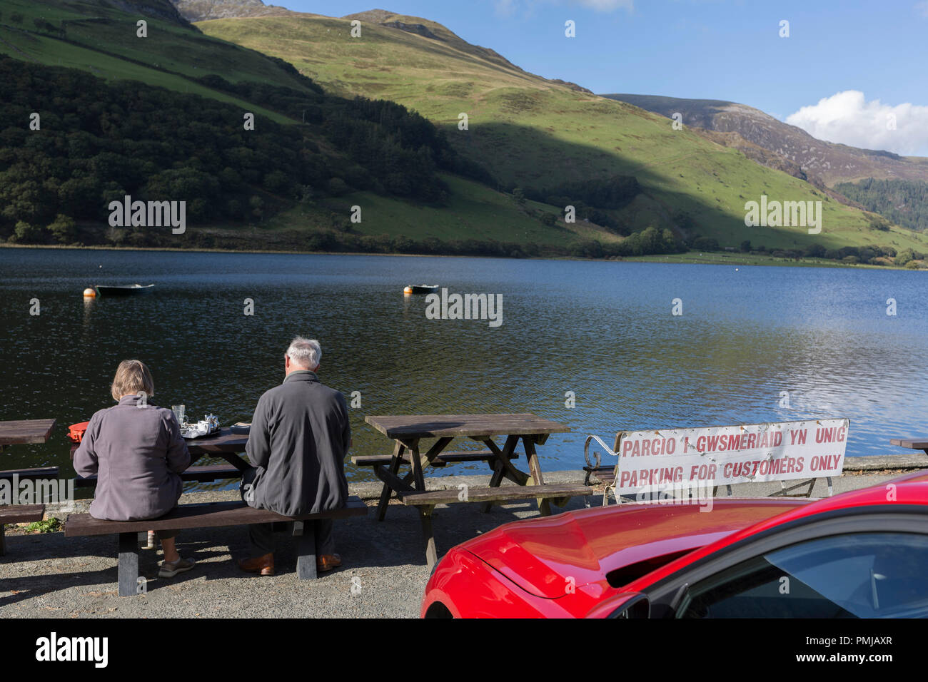 I visitatori che si affaccia su sit (lago) Tal-y-Llin e in lontananza le 2,928ft montagna Cader Idris, il 12 settembre 2018, vicino a Dolgellau, Gwynedd, Galles. Foto Stock