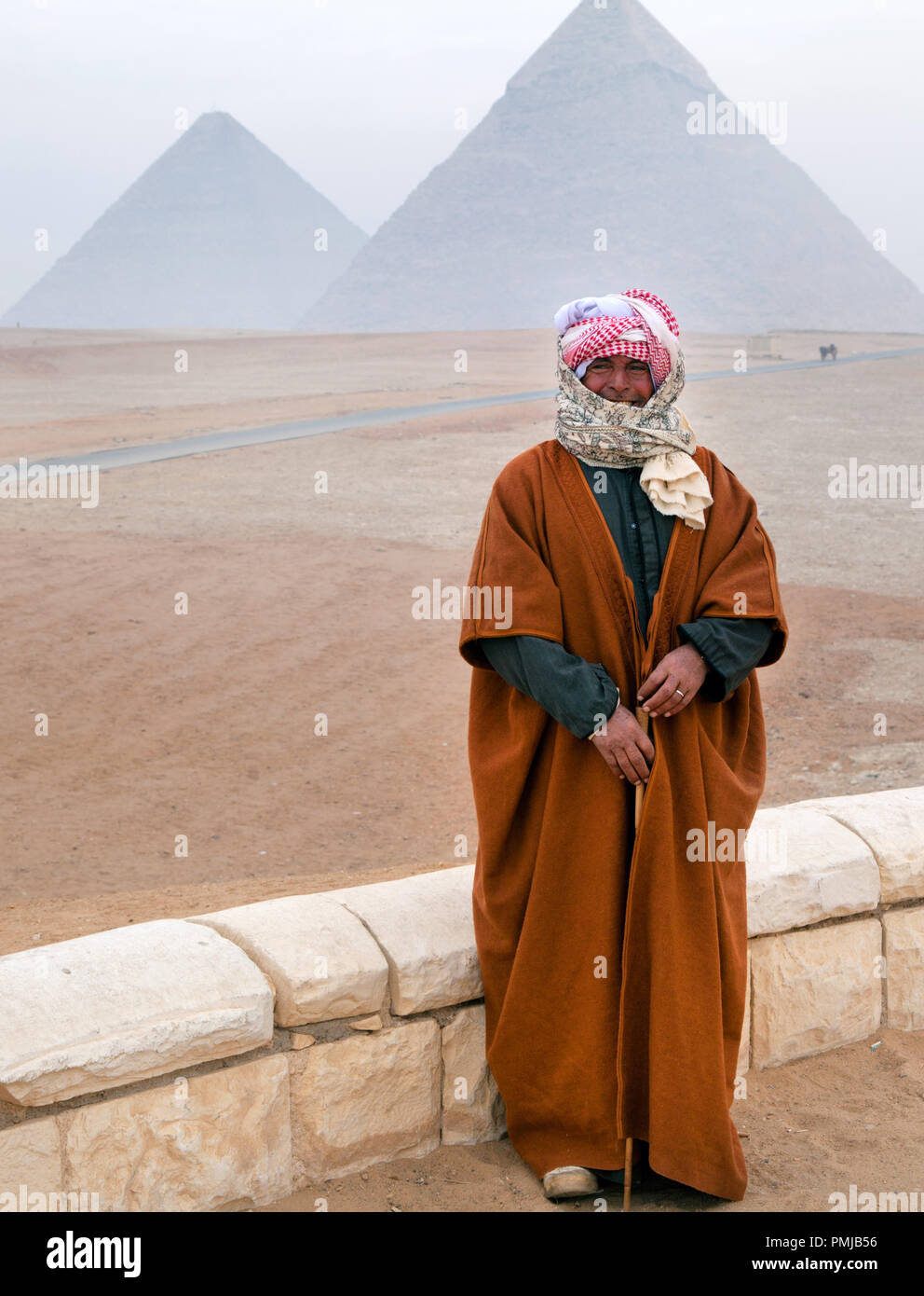 Un beduino si erge sullo sfondo delle grandi piramidi in Egitto Foto Stock