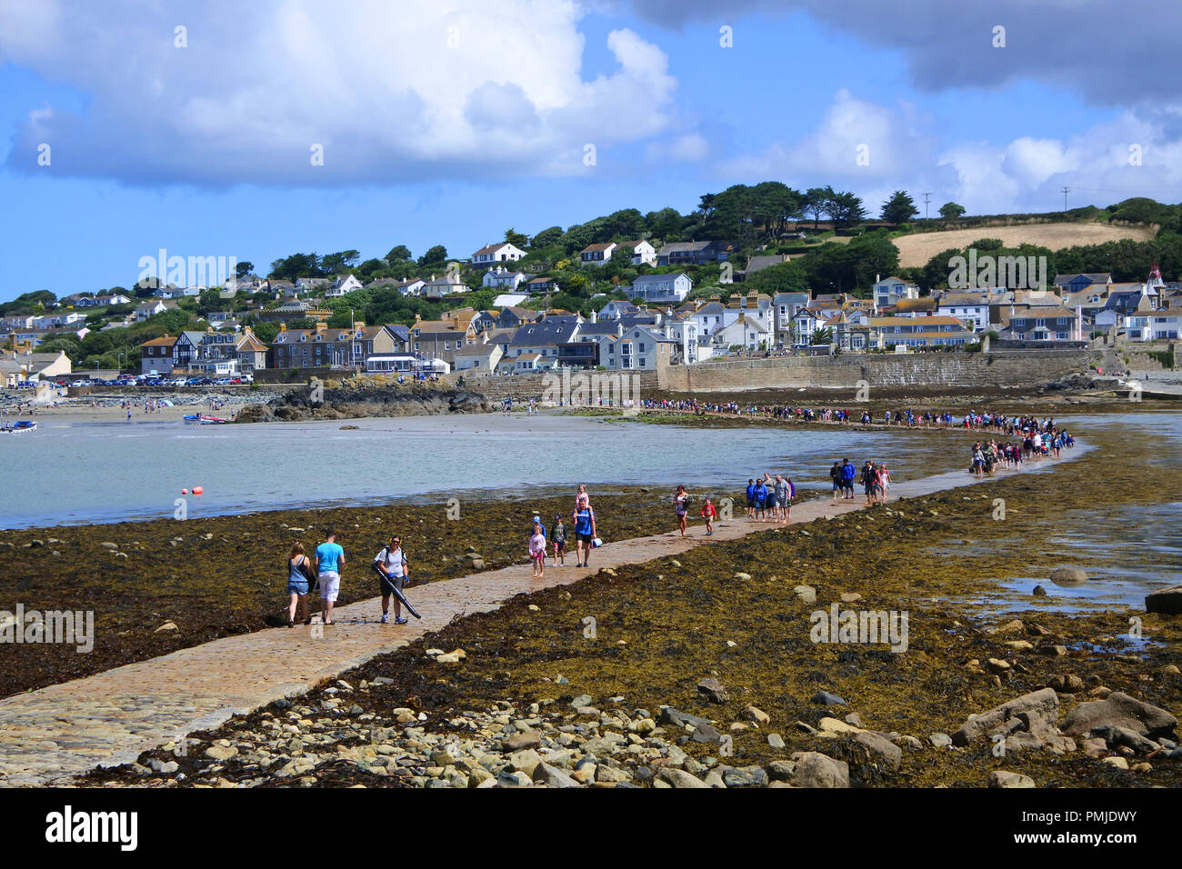 La folla di turisti a piedi attraversata la strada rialzata a St. Michael's Mount, Cornwall, Regno Unito - Giovanni Gollop Foto Stock