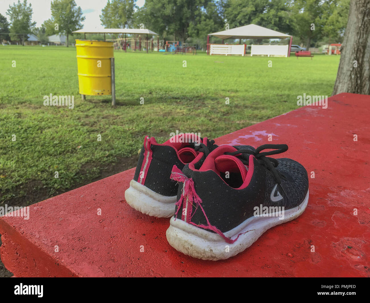 Scarpe scartato a sinistra su un parco pubblico tabella in Alpine Texas Foto Stock