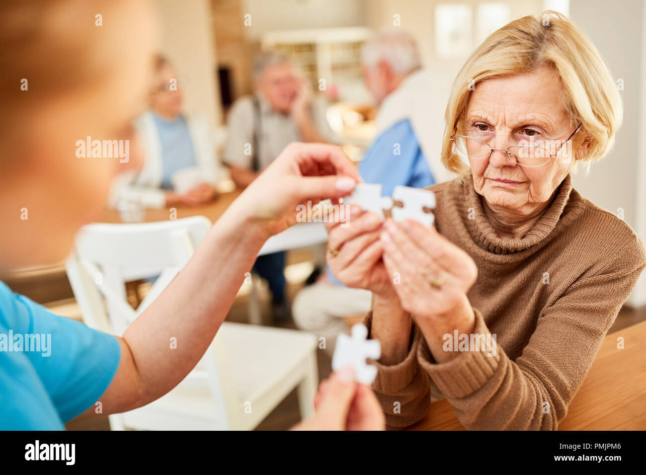 Senior con il morbo di Alzheimer o demenza ha difficoltà a giocare puzzle Foto Stock