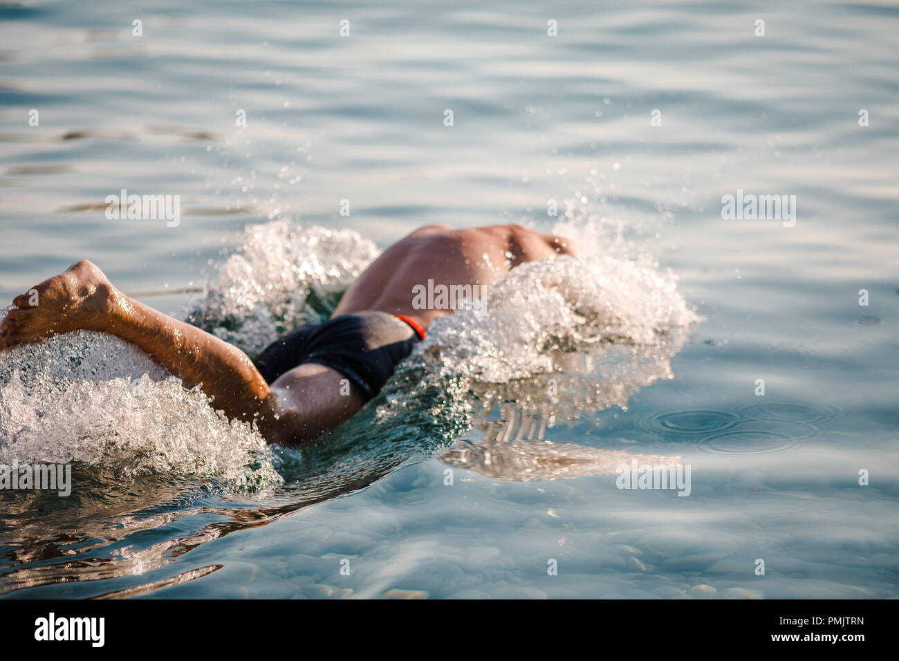 Voce maschile salto in acqua e avviare il nuoto Foto Stock