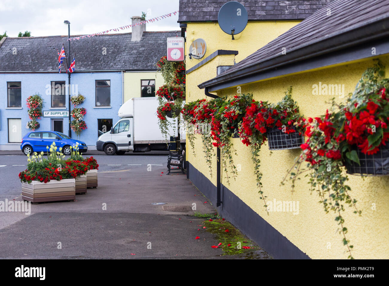 Cesti floreali pendenti e letti di fiori nel piccolo villaggio, Broughshane, County Antrim, N.Irlanda. Foto Stock