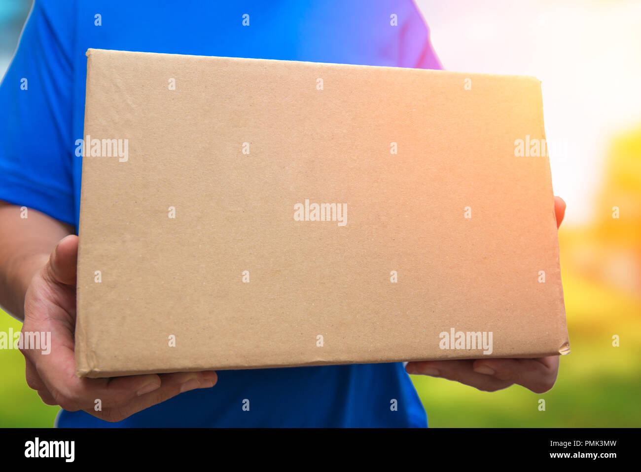 Uomo con scatola marrone pacchetto nave per la consegna a casa sua da online shopping mall Foto Stock