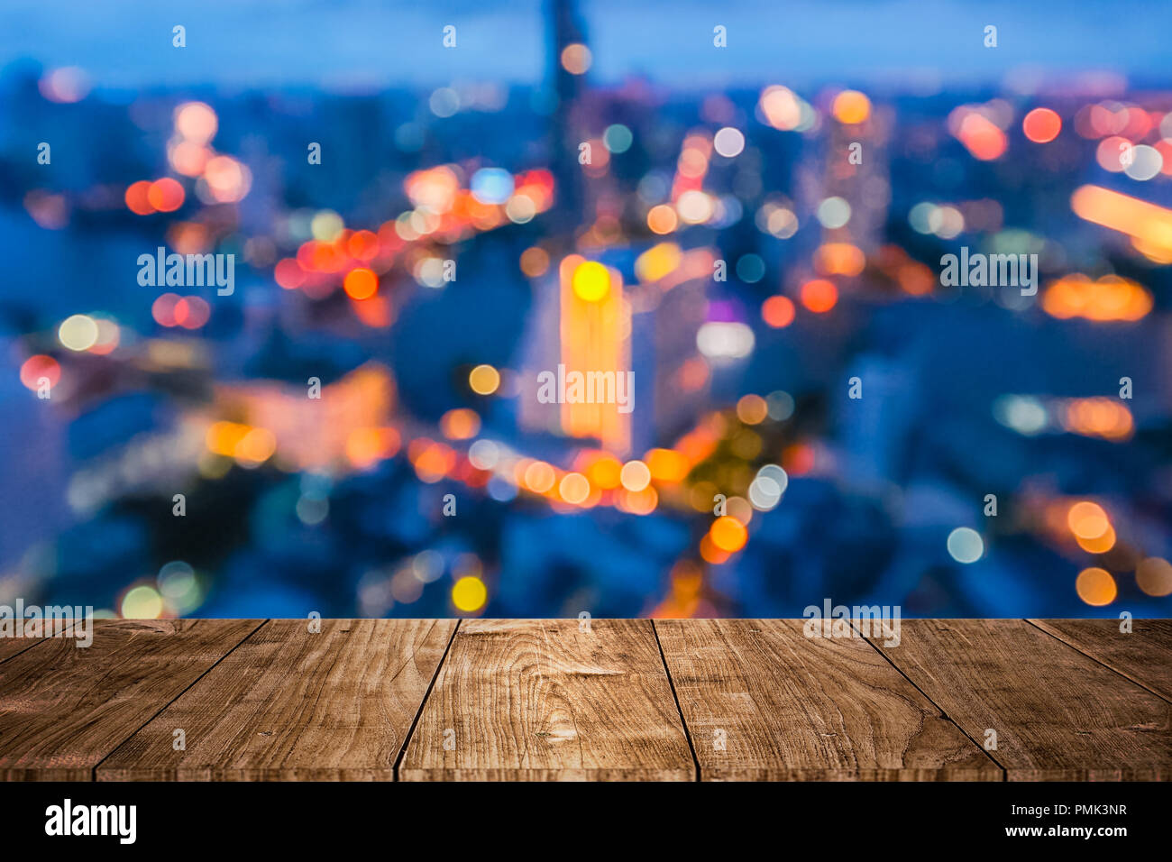 Tavolo in legno con blur city night bokeh design per le pubblicità di prodotto sullo sfondo del display Foto Stock