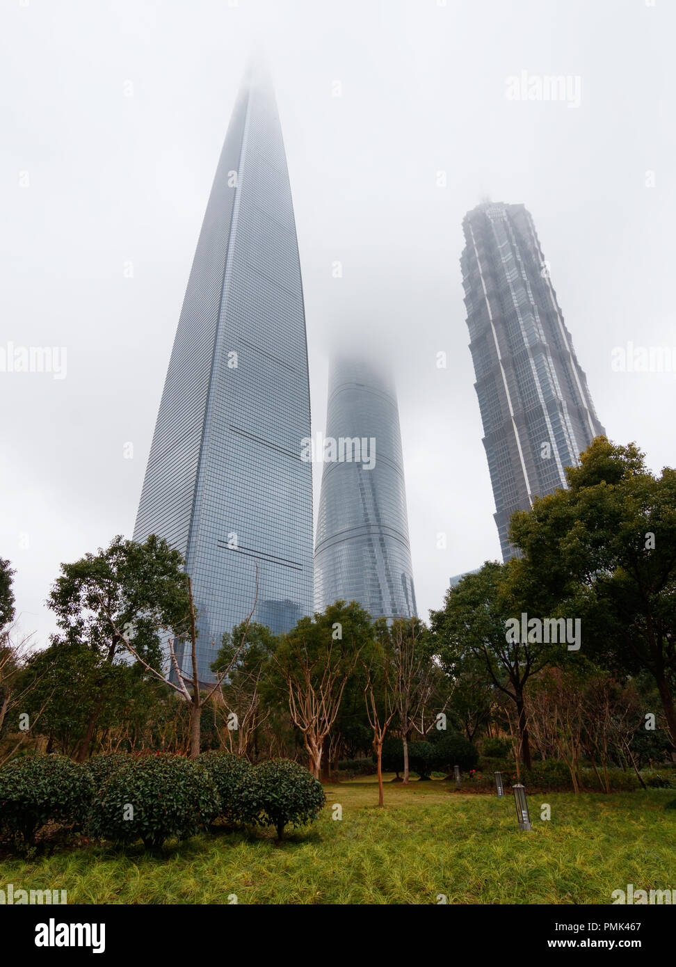 SHANGHAI, Cina - Jan 22, 2018: Shanghai Tower, centro finanziario e Jin Mao grattacieli tops coperti dalla nebbia da sotto Foto Stock