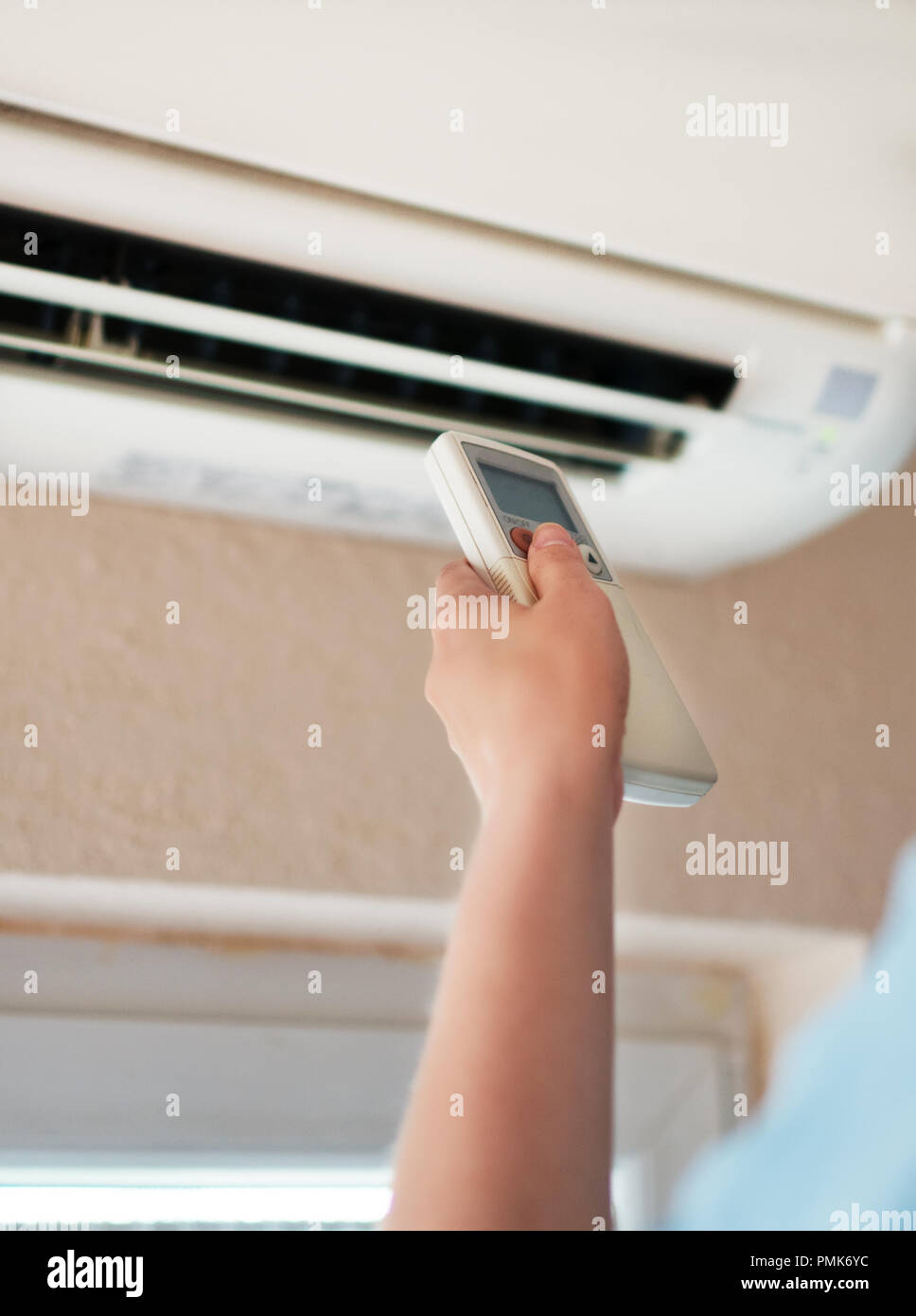 Mano che tiene il telecomando finalizzate al condizionatore d'aria. Foto Stock