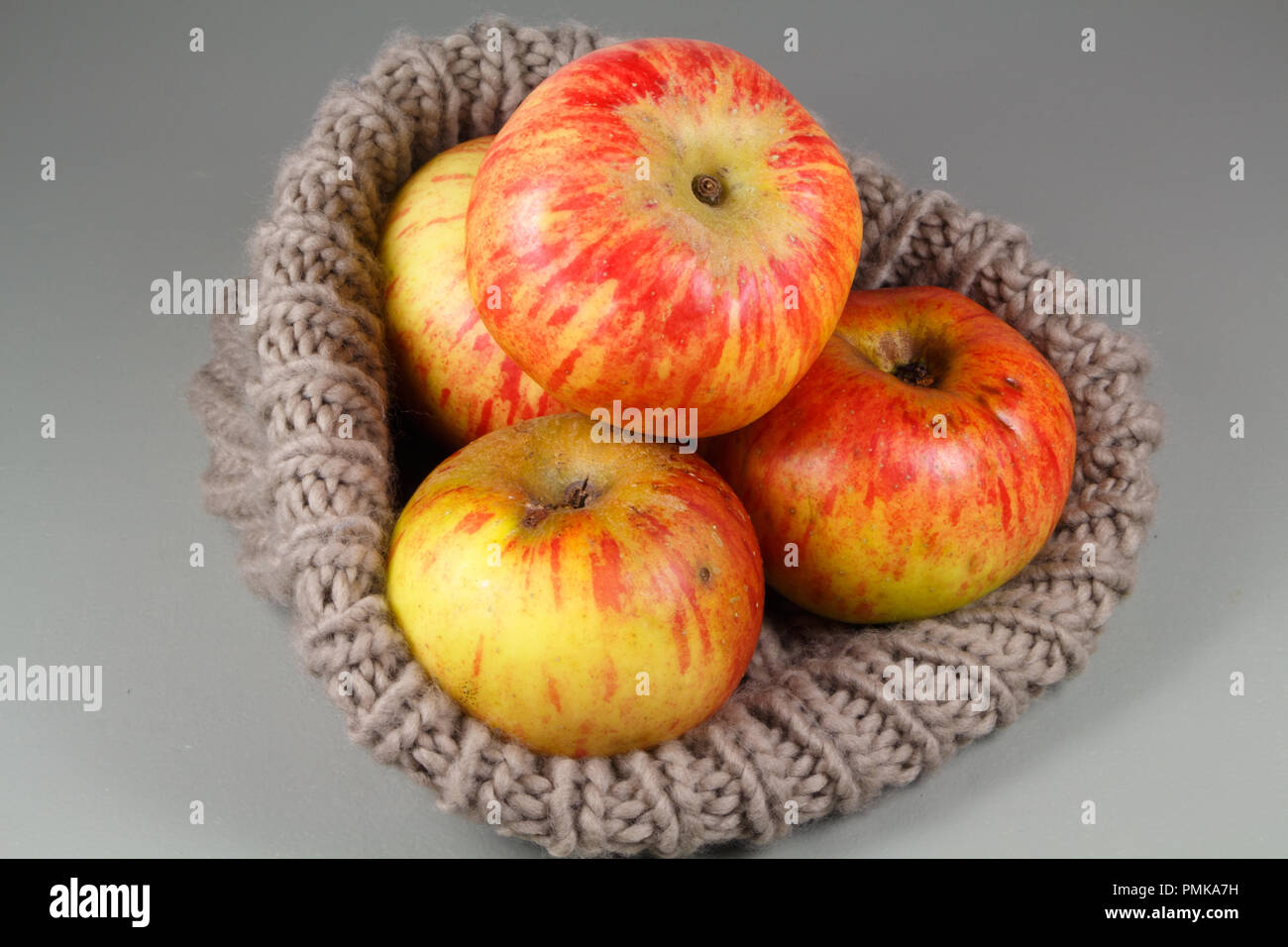 Il rosso e il giallo le mele in un beige beanie dopo il raccolto Foto Stock