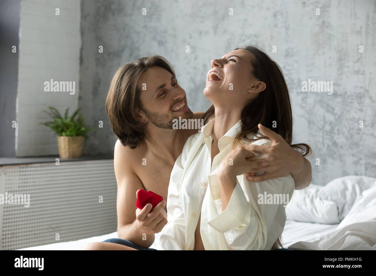 Amorevole fidanzato rendendo proposta di matrimonio alla fidanzata in bedro Foto Stock