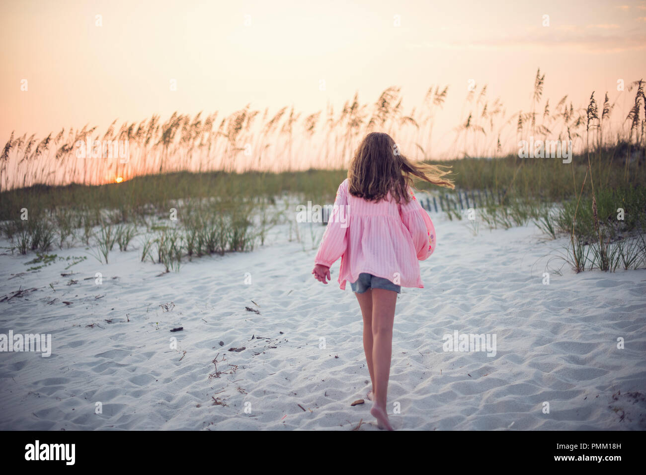 Ragazza camminare sulla spiaggia al tramonto, Florida, Stati Uniti Foto Stock