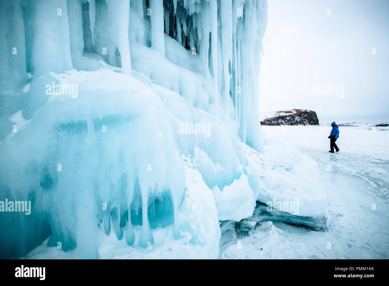 Uomo che cammina verso una grotta congelato, Siberia, Russia Foto Stock