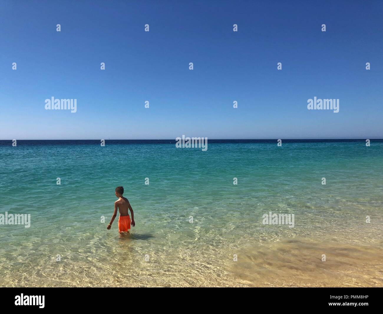 Ragazzo passeggiate in mare, Playa de Morro Jable Fuerteventura Isole Canarie, Spagna Foto Stock