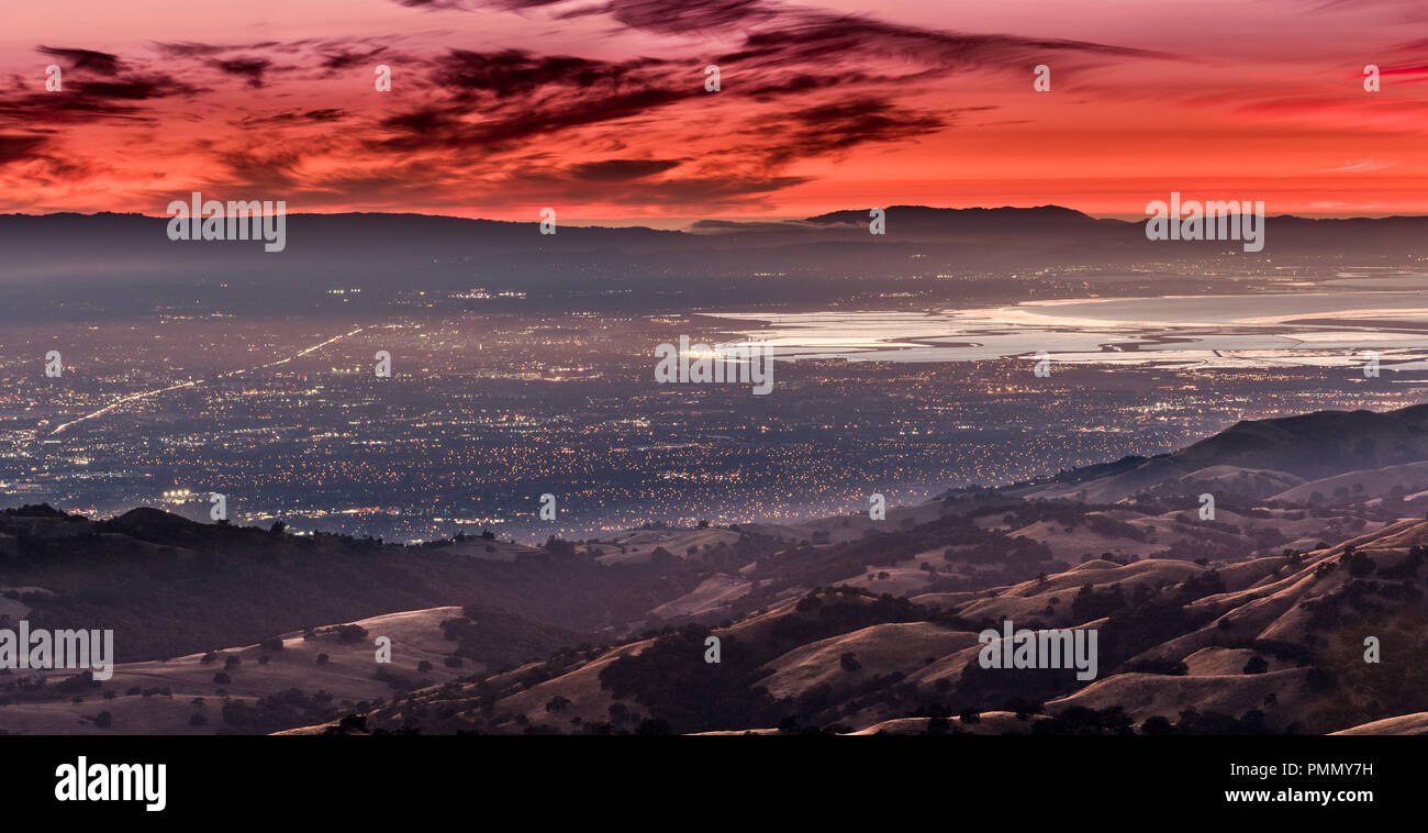 Notte vedute della città di Silicon Valley; le luci della città di San Jose, di Santa Clara e di altre città del sud di San Francisco Bay sotto un cielo rosso Foto Stock