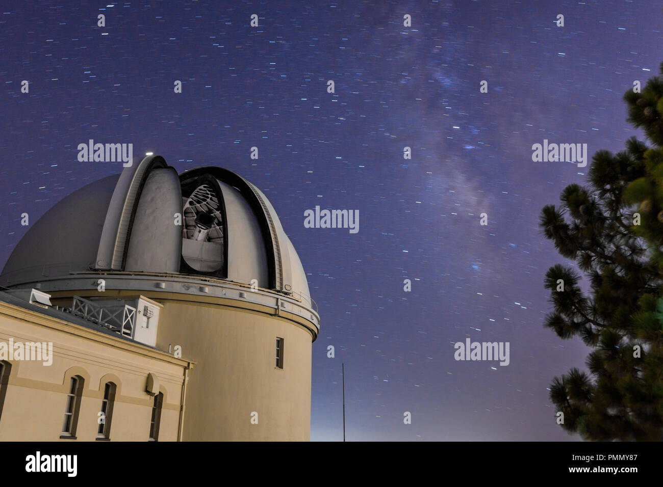 Vista notturna del centro storico di leccare osservatorio; il cielo stellato e la Via Lattea visibile in background; San Jose, California; lunga esposizione Foto Stock