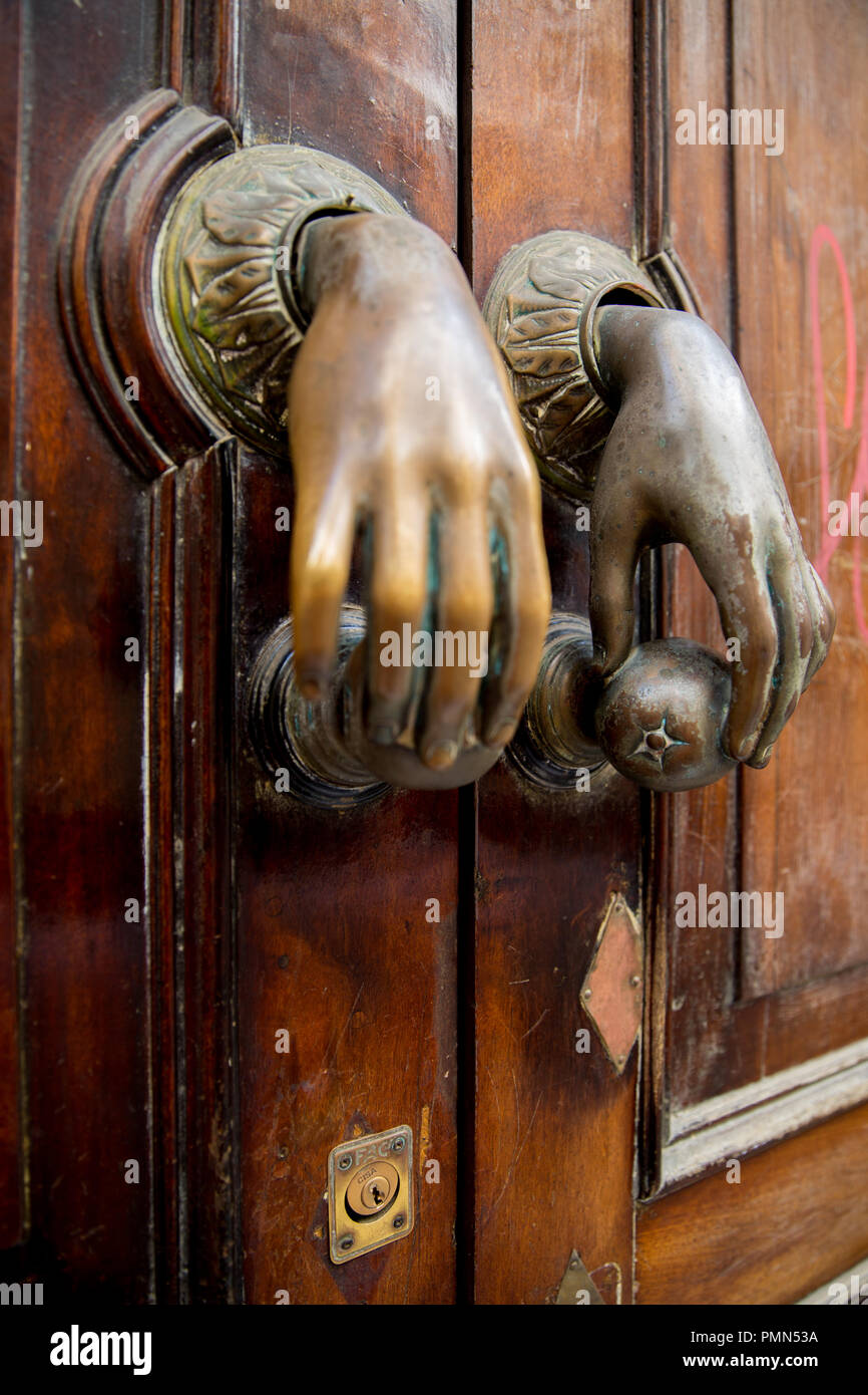 Una coppia di porta in ottone battenti di esili mani femminili azienda  arance posto su una porta di legno, in una strada di spagnolo Foto stock -  Alamy