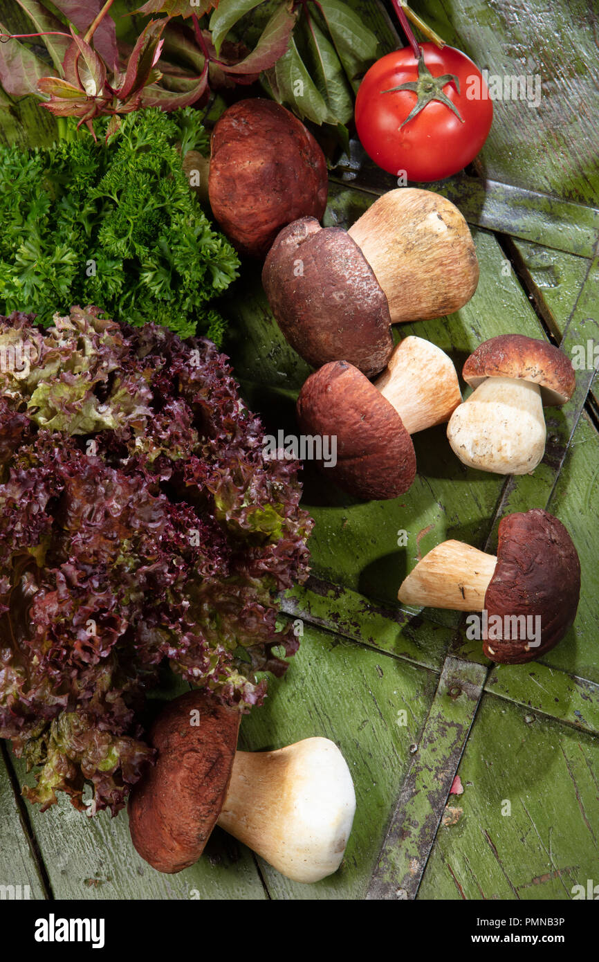 Funghi e verdure su un vecchio legno Foto Stock
