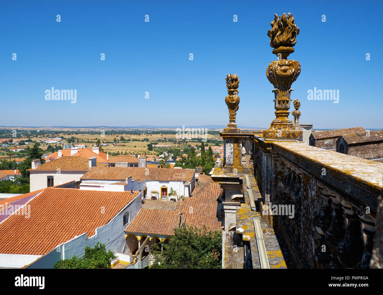 La vista della pietra decorativa fiaccole sul balcone di Evora Cattedrale (Se) con la città residenziale case e campi sullo sfondo. Evora. Porto Foto Stock