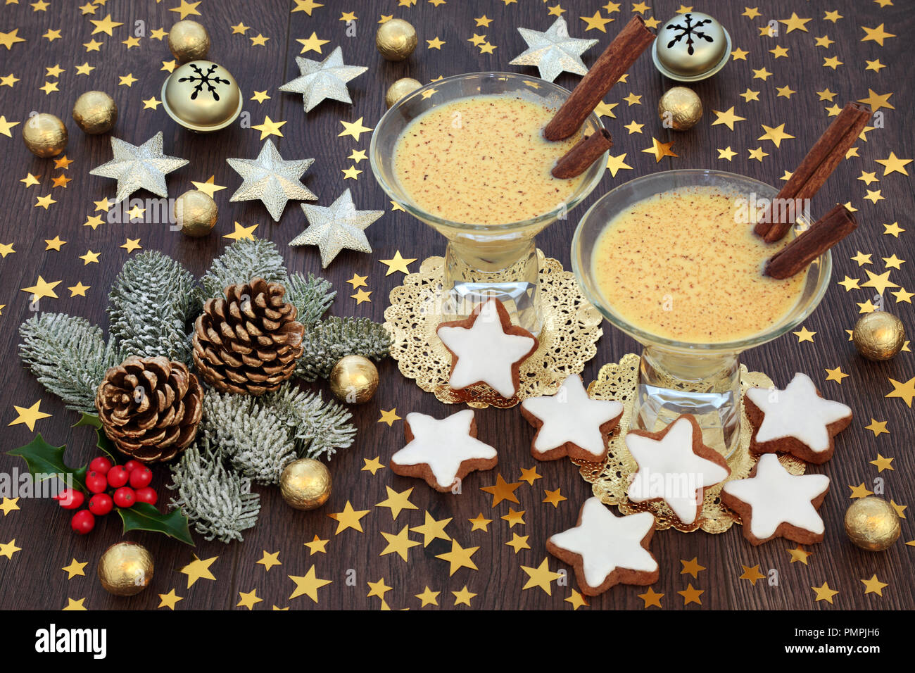 Natale tradizionale bevanda zabaione con biscotti di panpepato, stella in oro e decorazioni a campana, stagnola avvolto le sfere di cioccolato con flora d'inverno. Foto Stock