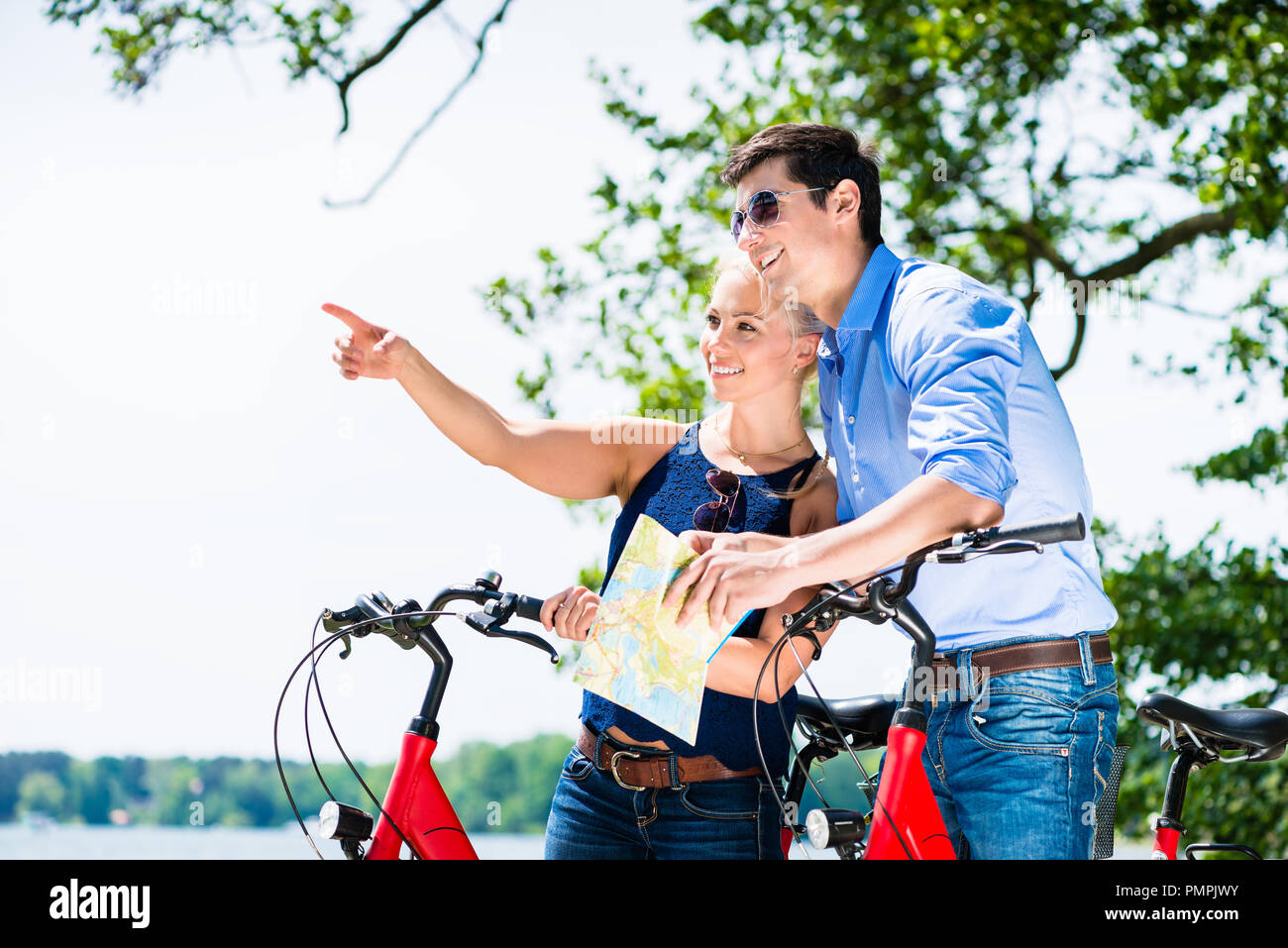 Giovane Azienda mappa in piedi con le biciclette Foto Stock