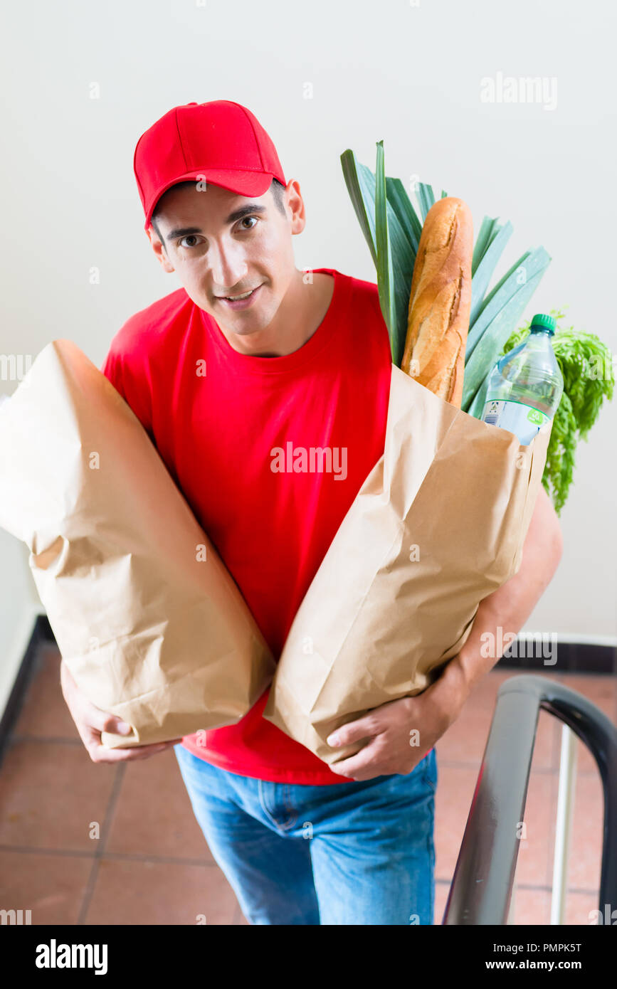 Negozio di generi alimentari per la consegna con corriere di sacchetti di carta di cibo Foto Stock