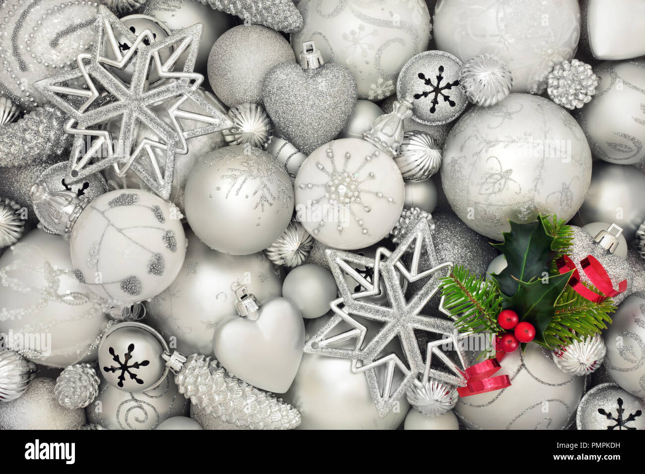 Natale sfondo astratto con lusso bianco e argento ninnolo decorazioni con holly e fir rametto di foglia. Natale tradizionale biglietto di auguri. Foto Stock
