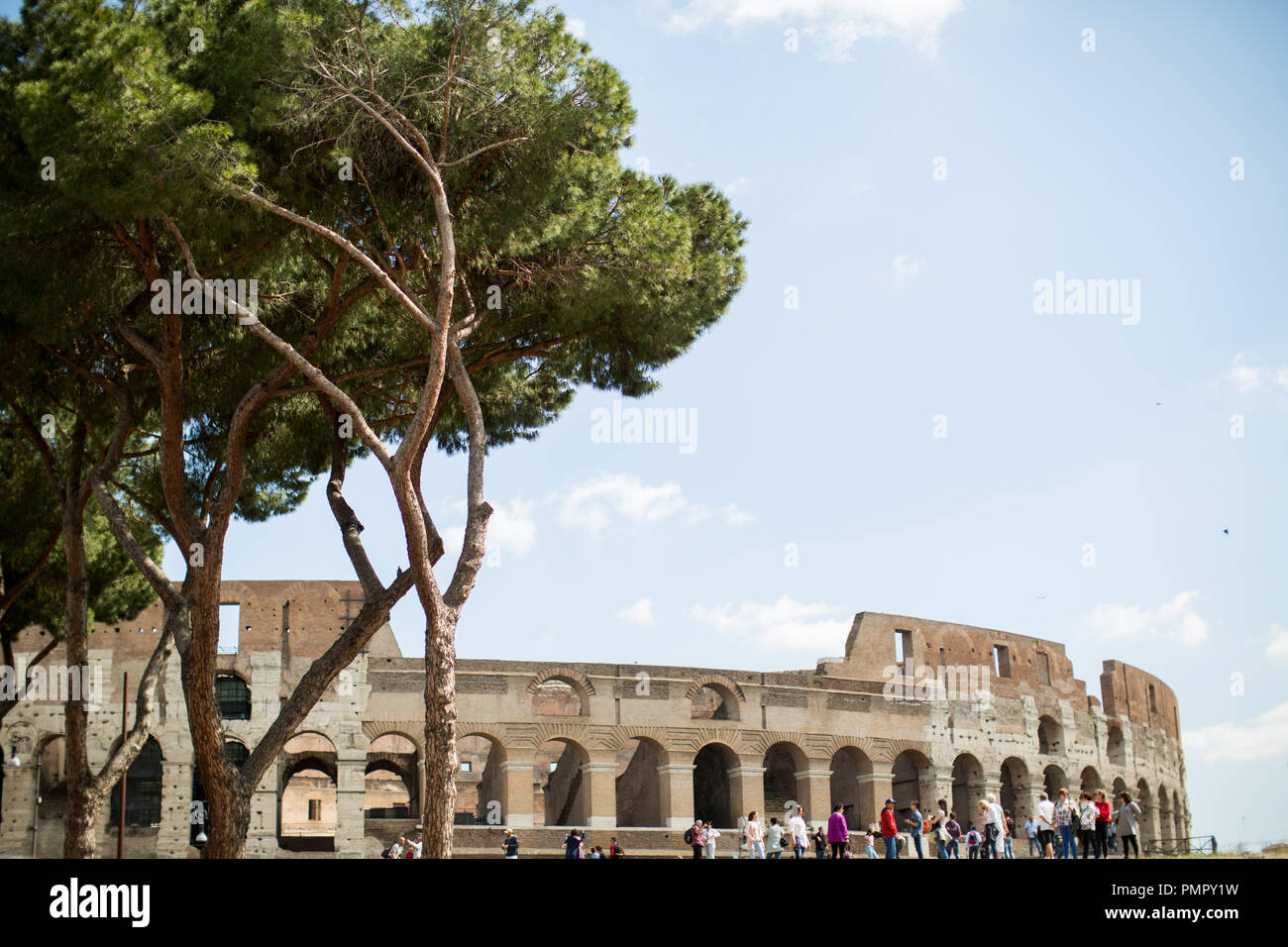 I turisti davanti al Colosseo a Roma. Le persone sono piccole con il Colosseo in background Foto Stock