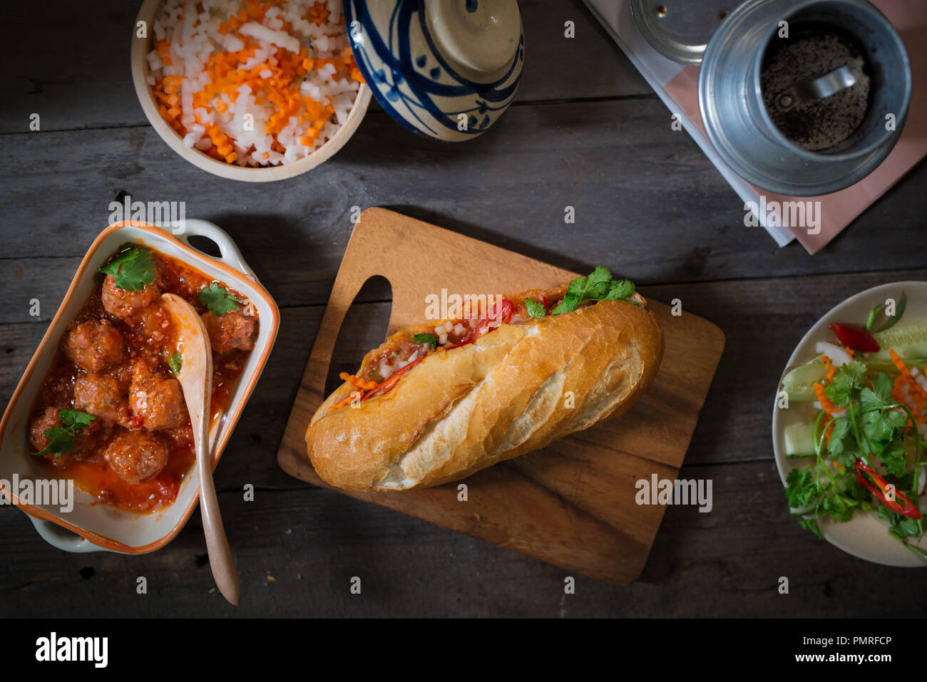 Sandwich vietnamita pane con le polpette di carne in salsa di pomodoro e ravanelli, carota pickle, cetriolo, coriandolo. Foto Stock