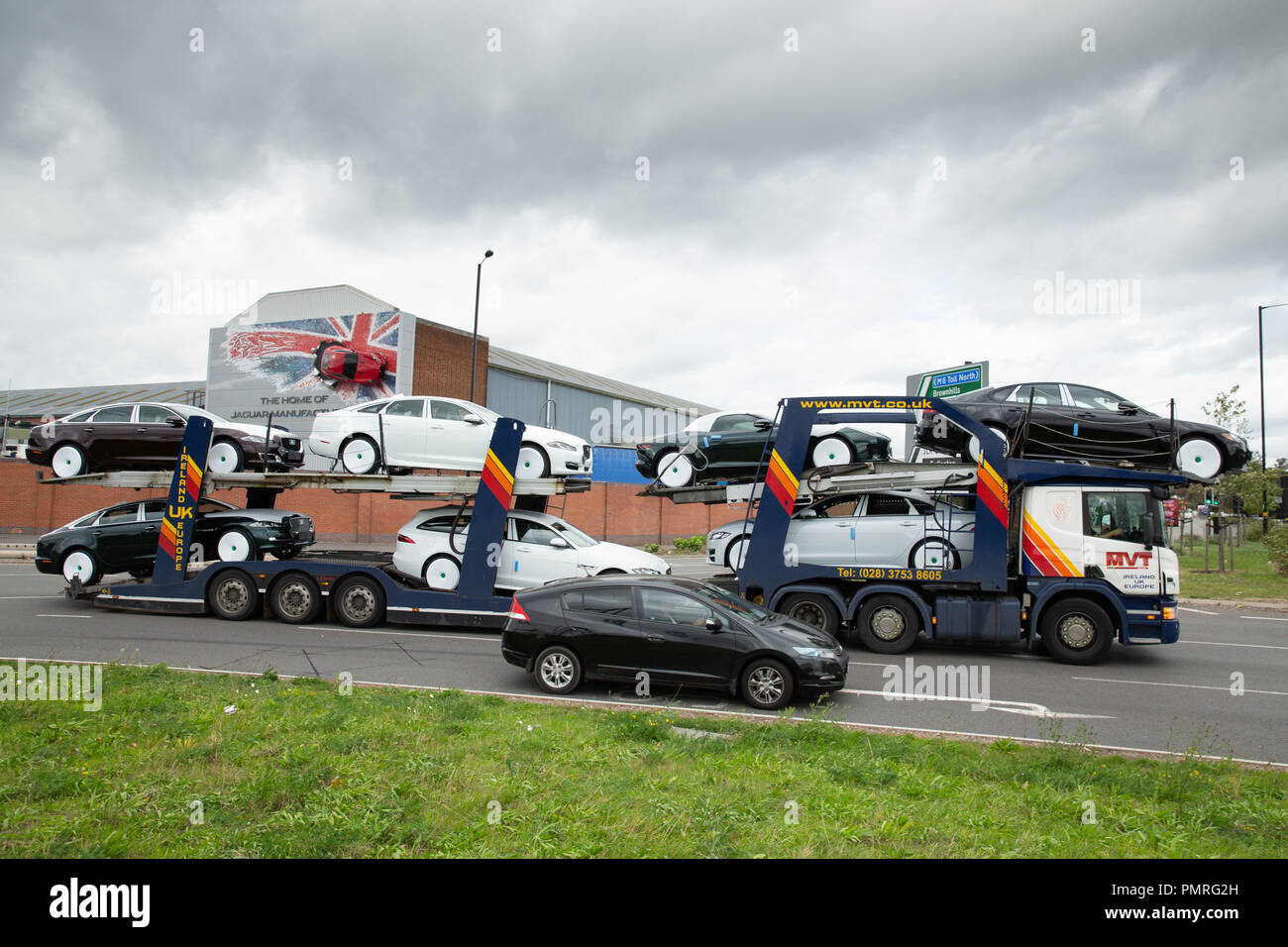 Un auto transporter portando Jaguar Landrover auto lascia il Castle Bromwich fabbrica in Birmingham. Foto Stock