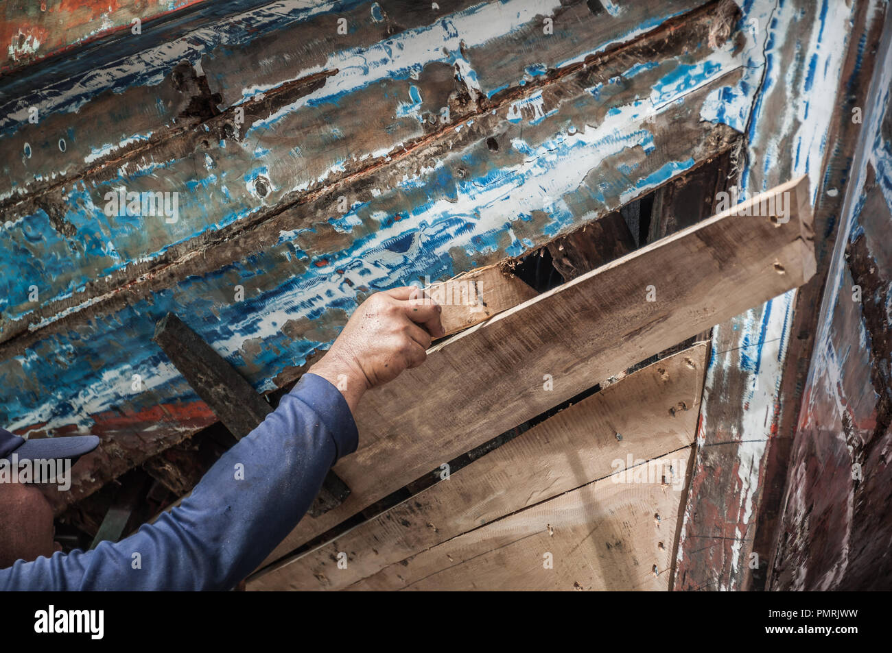 Manutenzione meccanica vecchia barca di legno sulla spiaggia con la mano, la pesca tradizionale baia della Thailandia Foto Stock