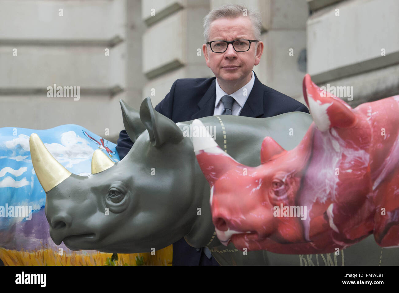 Ambiente segretario Michael Gove con il brosmio fiducia rhino statue d'arte al di fuori del Foreign Office di Londra, precedendo il traffico illegale di fauna selvatica Trade Conference. Foto Stock