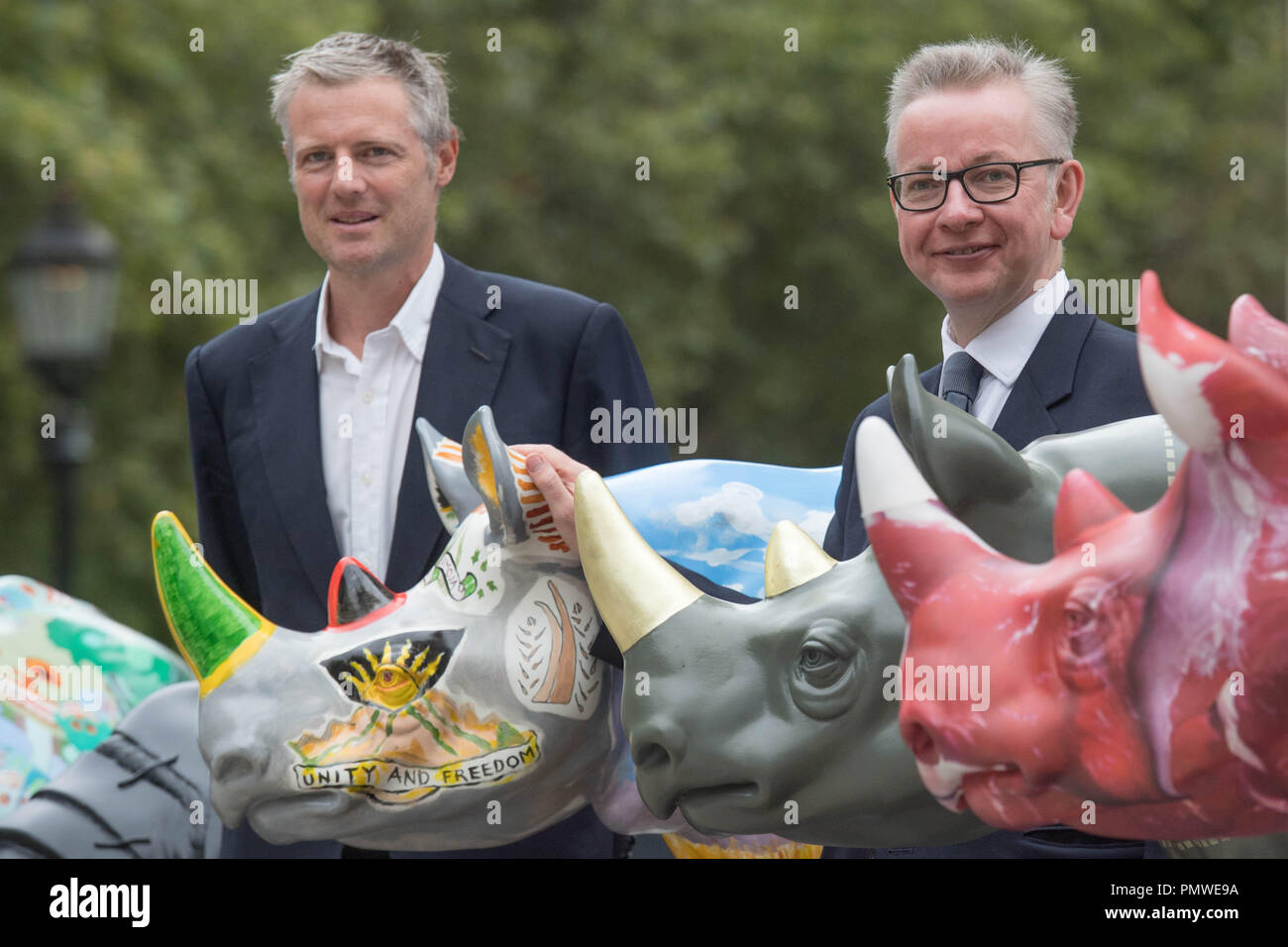 Ambiente segretario Michael Gove (destra) e Zac Goldsmith con il brosmio fiducia rhino statue d'arte al di fuori del Foreign Office di Londra, precedendo il traffico illegale di fauna selvatica Trade Conference. Foto Stock