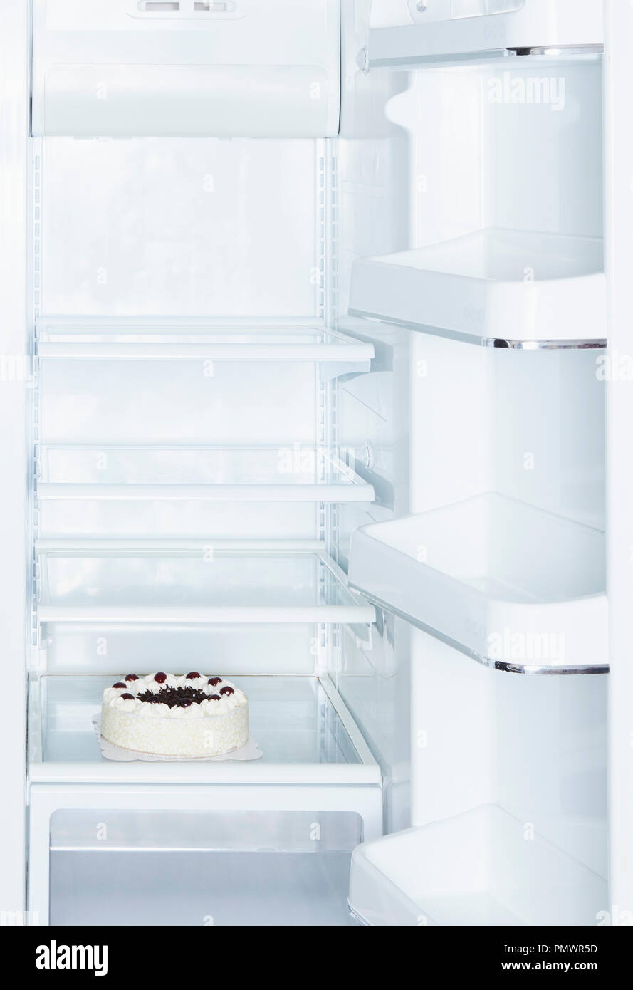 Torta della Foresta nera in open, vuoto frigorifero bianco Foto Stock