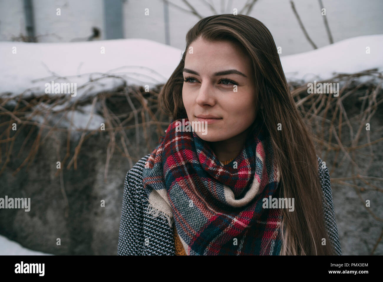 Considerato giovane donna in plaid sciarpa che guarda lontano Foto Stock