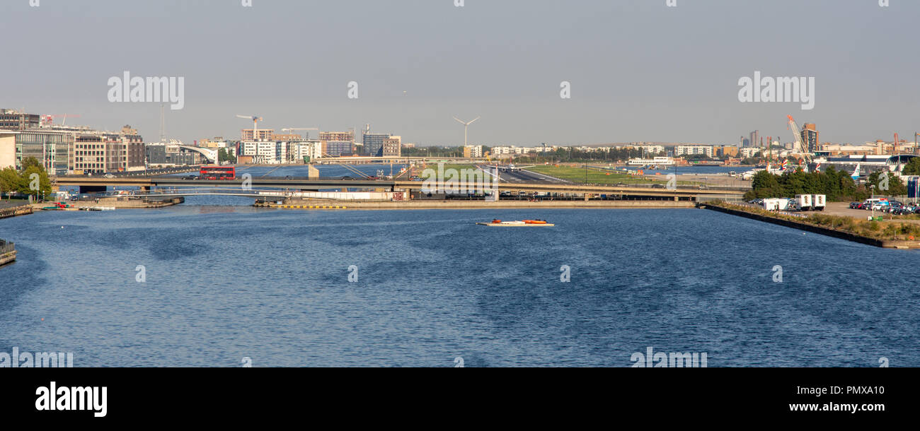 London, England, Regno Unito - 2 Settembre 2018: il traffico attraversa il Royal Docks su Connaught Bridge mentre un aereo taxi lungo la pista della City di Londra un Foto Stock
