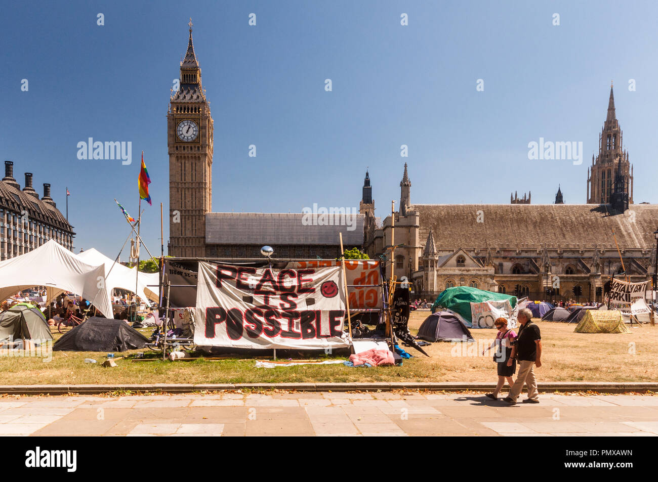 London, England, Regno Unito - 4 Luglio 2010: pedoni a piedi passato la democrazia protesta Villaggio camp che occupa la piazza del Parlamento, al di fuori delle case di Parlia Foto Stock