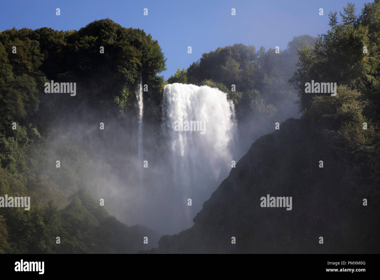 La Cascata delle Marmore in Umbria, Italia. La Cascata delle Marmore, o della Cascata delle Marmore Falls, è un uomo fatto cascata creata dagli antichi romani. La sua altezza totale è di 165m, il che lo rende il più alto man-made cascata nel mondo. La sua origine è una porzione delle acque del fiume Velino, dopo aver attraversato il lago di Piediluco vicino alla comunità di Cascata delle Marmore. Il suo flusso viene attivato e disattivato secondo un orario pubblicato, per soddisfare le esigenze di turisti e il potere società simili. Turisti cerca di essere lì nel momento in cui le porte sono aperte per vedere il potente rush di acqua. Foto Stock