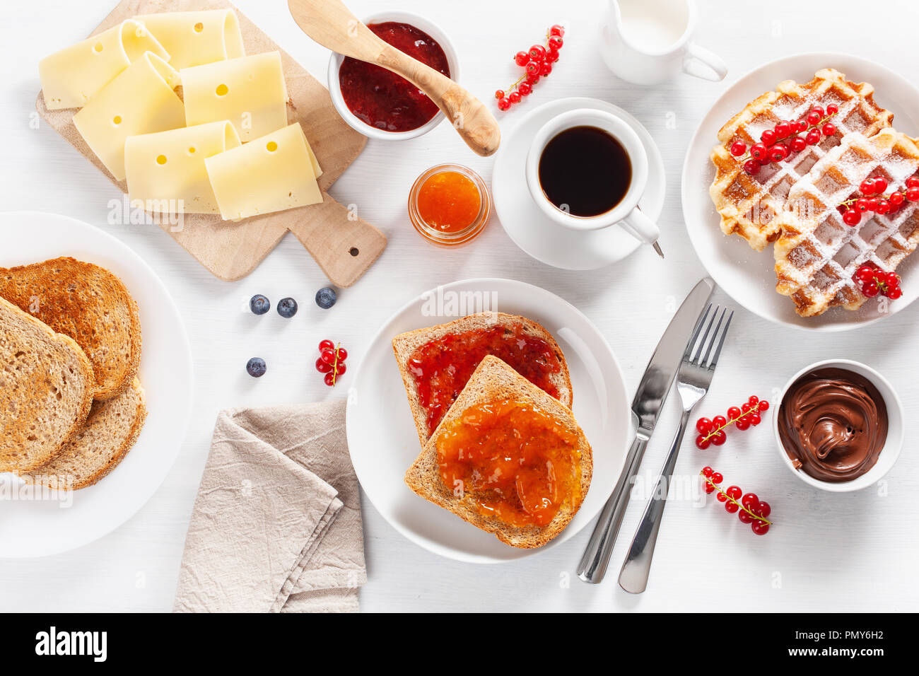 La prima colazione con cialde, toast, Berry, marmellata, cioccolata spalmabile e caffè. Vista superiore Foto Stock