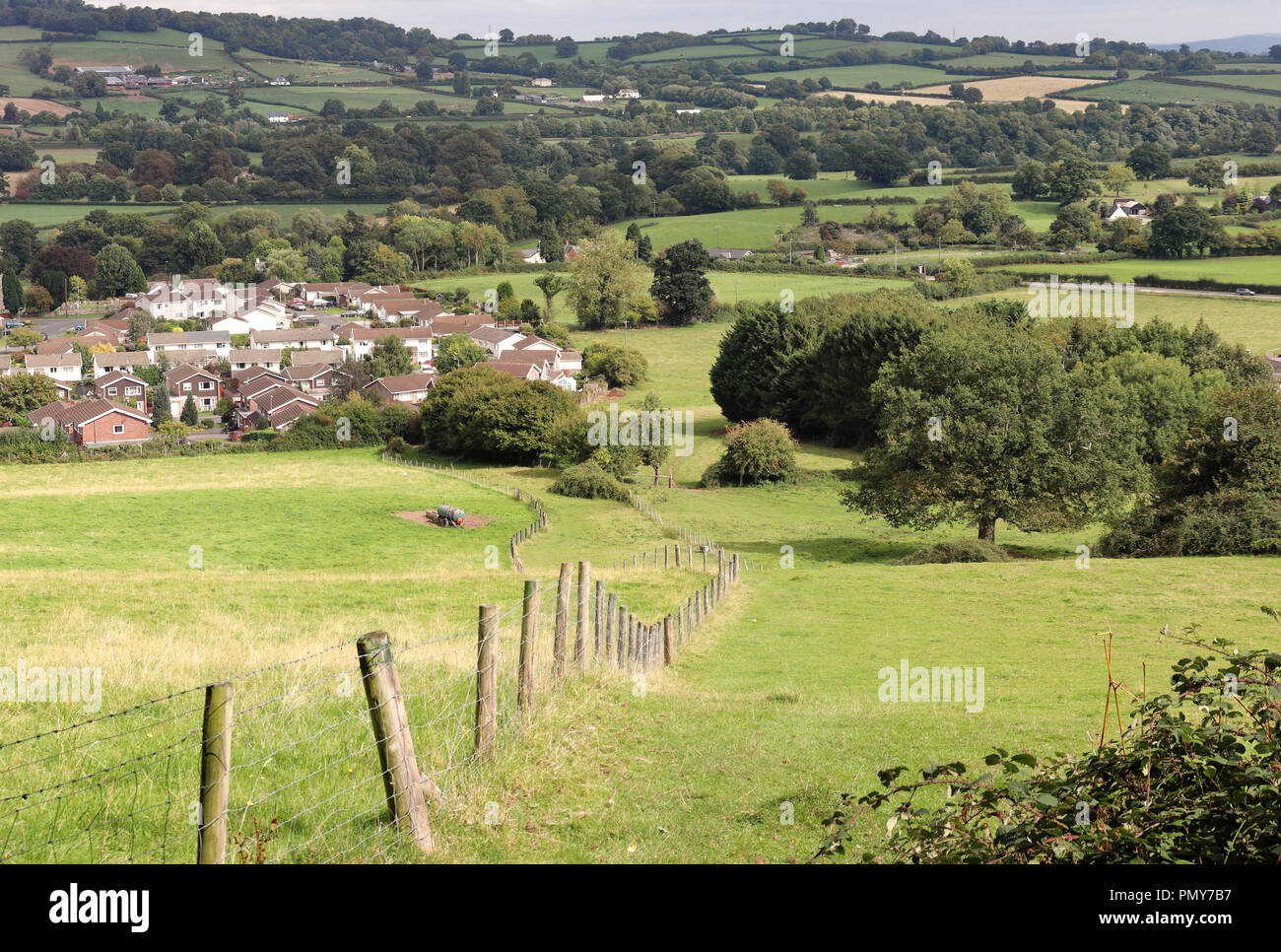 Un paesaggio rurale in Monmouthshire Galles del Sud con il villaggio di distanza Foto Stock