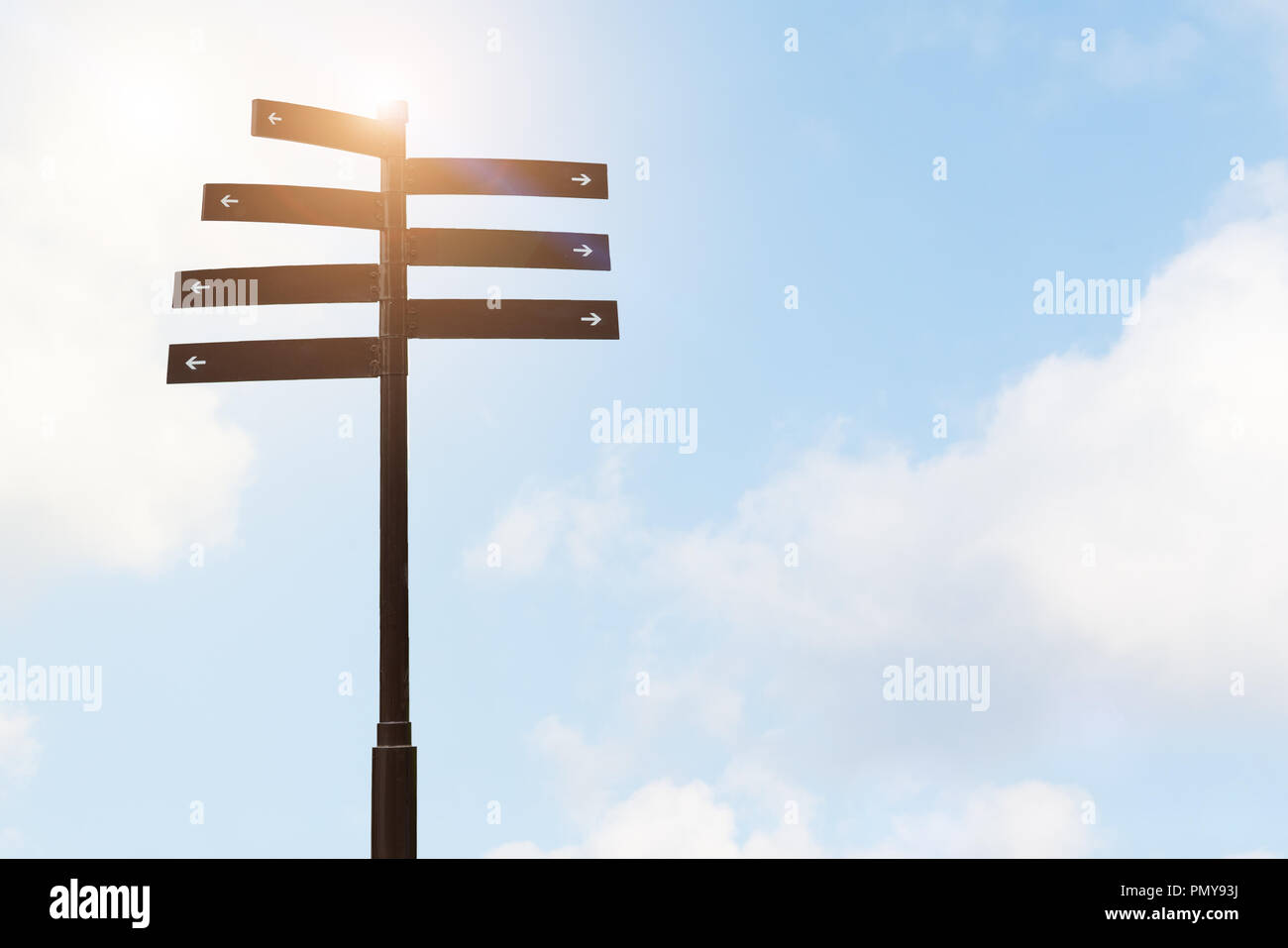 Guida di orientamento per segno di direzione su un palo con cielo blu sfondi Foto Stock