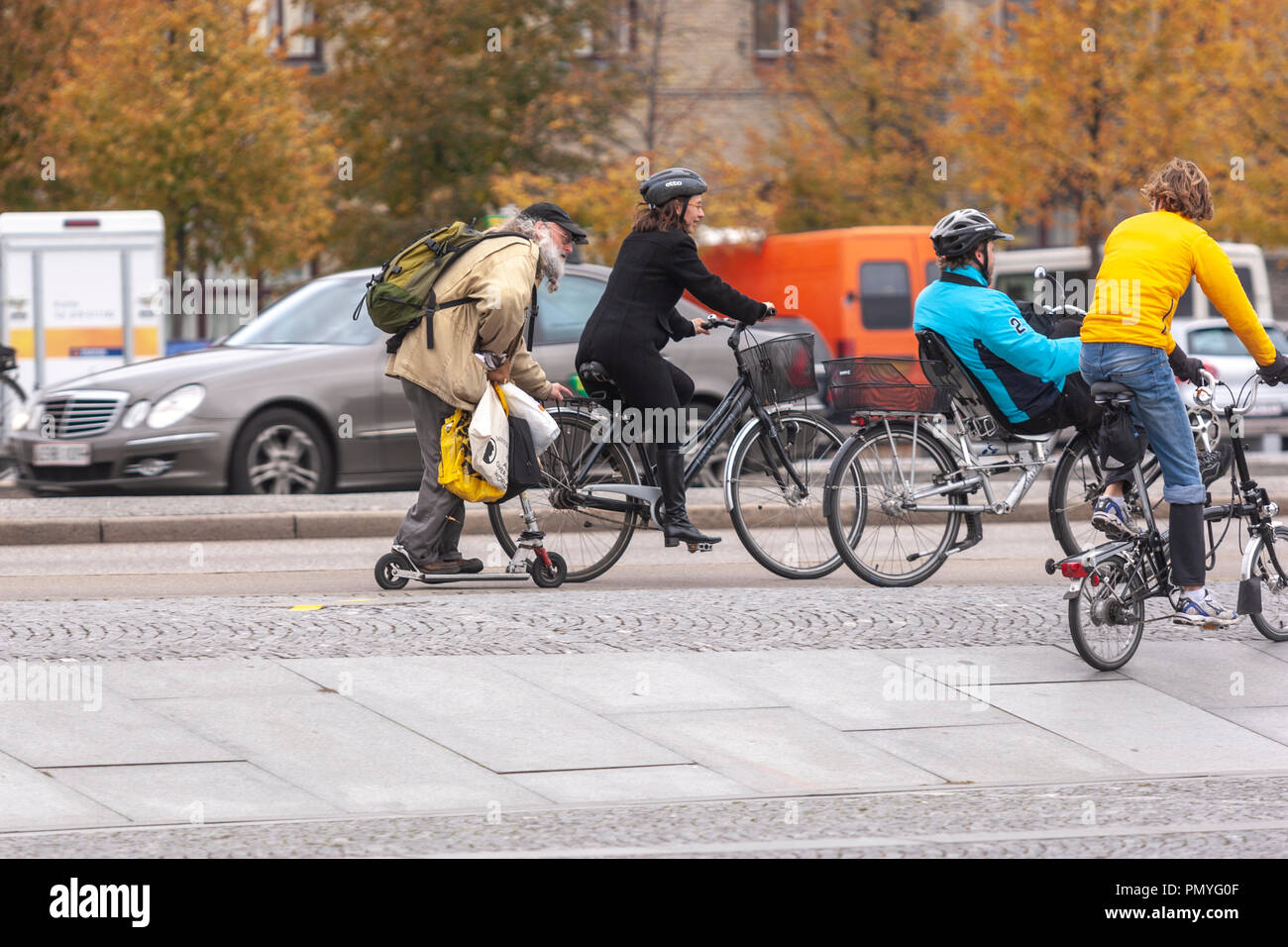 Il vecchio uomo in uno scooter afferrando una bici la guida da una ragazza in Søren Kierkegårds Plads, Copenhagen, Danimarca Foto Stock Il vecchio uomo in uno scooter afferrando una bici la guida da una ragazza in Søren Kierkegårds Plads, Copenhagen, Danimarca Foto Stock