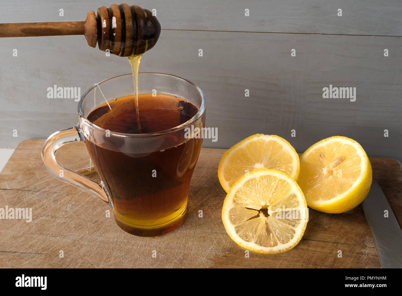 Naturale di trattamento a freddo e rimedi su sfondo di legno. Il tè caldo con organici di limone e il miele. Foto Stock