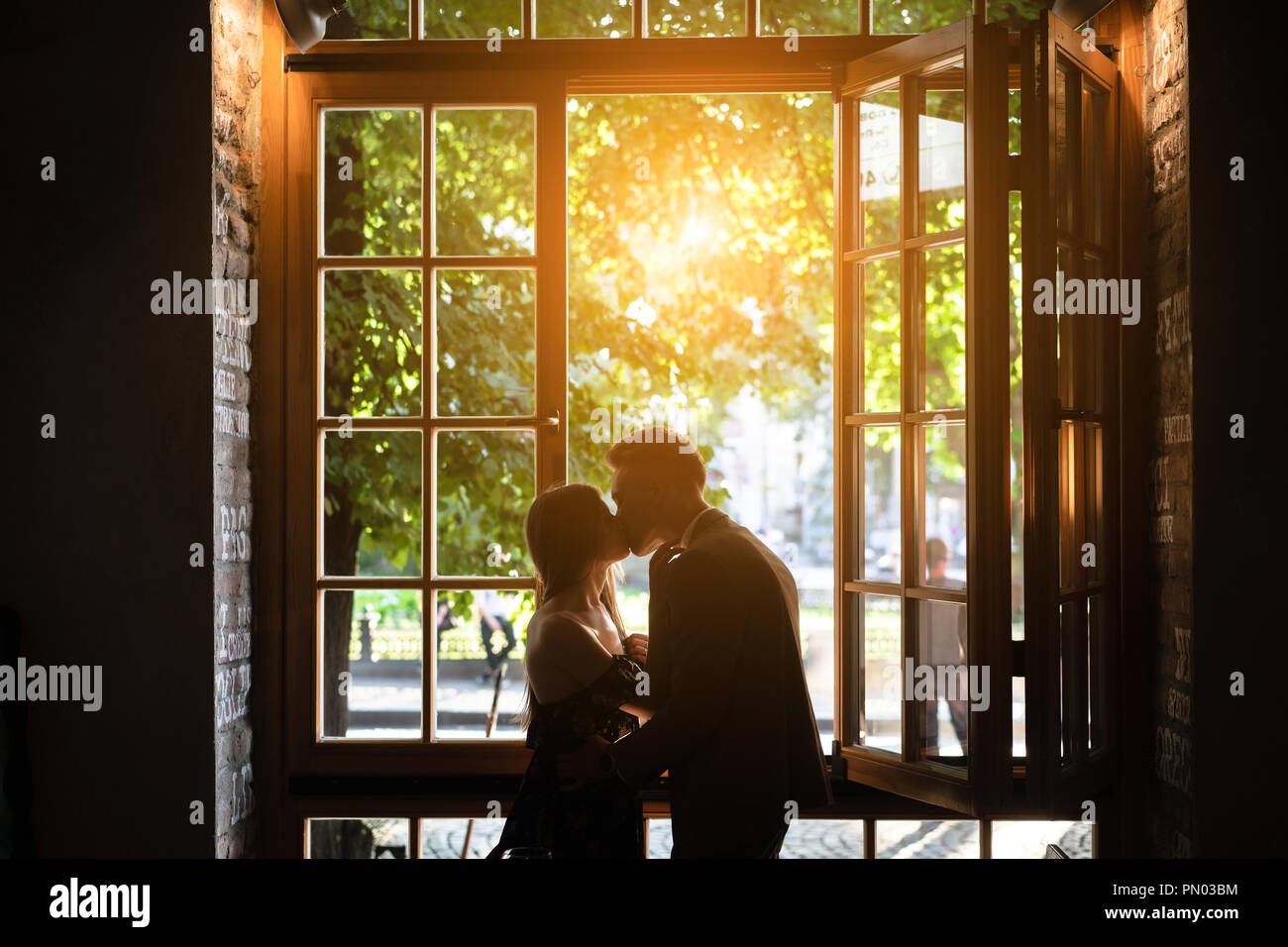 Coppia giovane in amore in piedi dalla finestra Foto Stock