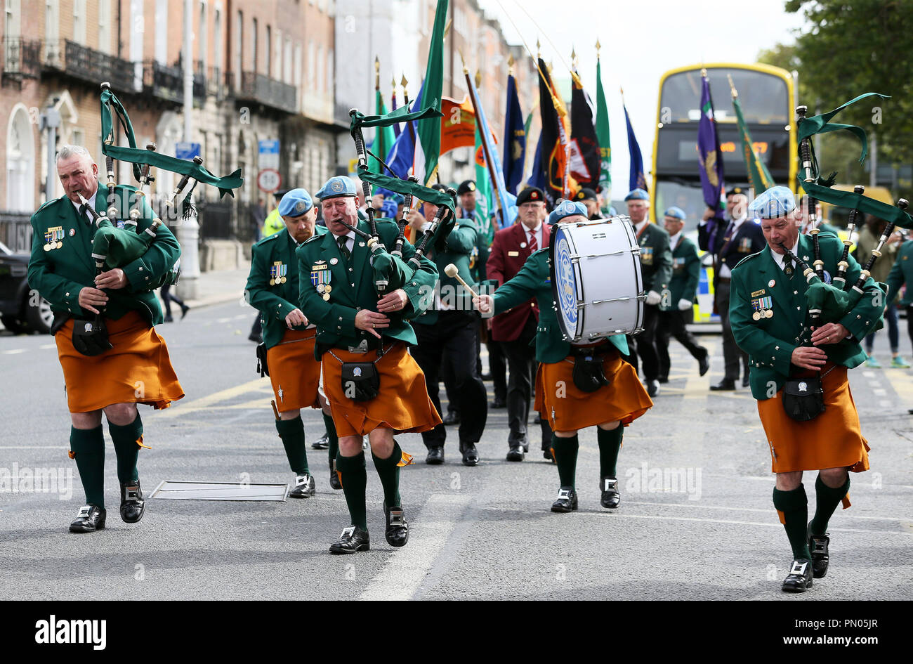 I membri delle Nazioni Unite veterani pipe band in lotta con il vento forte durante la sfilata di un corteo per il rispetto e la fedeltà per la difesa irlandese forze al Merrion Square a Dublino. Foto Stock