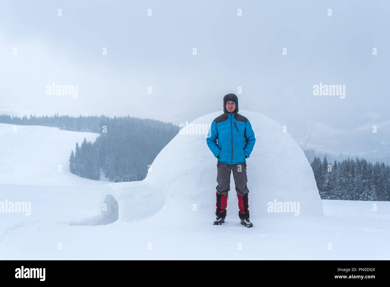 Eschimese igloo in montagna. Avventure invernali in escursione. Guy turisti in un down jacket Foto Stock