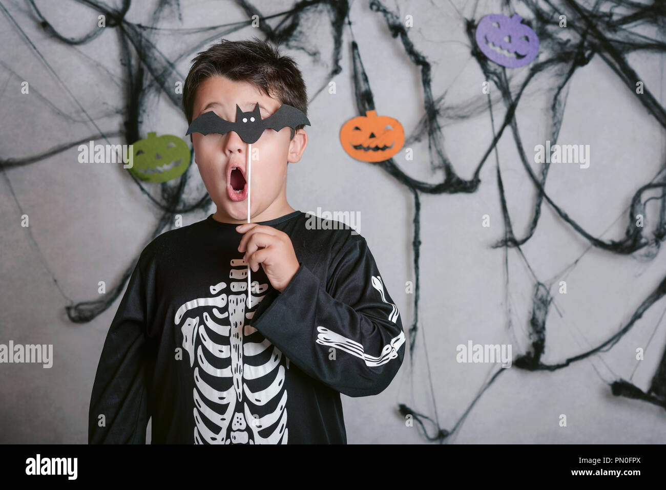 Bambino con un bat che copre il suo occhio alla festa di Halloween Foto Stock