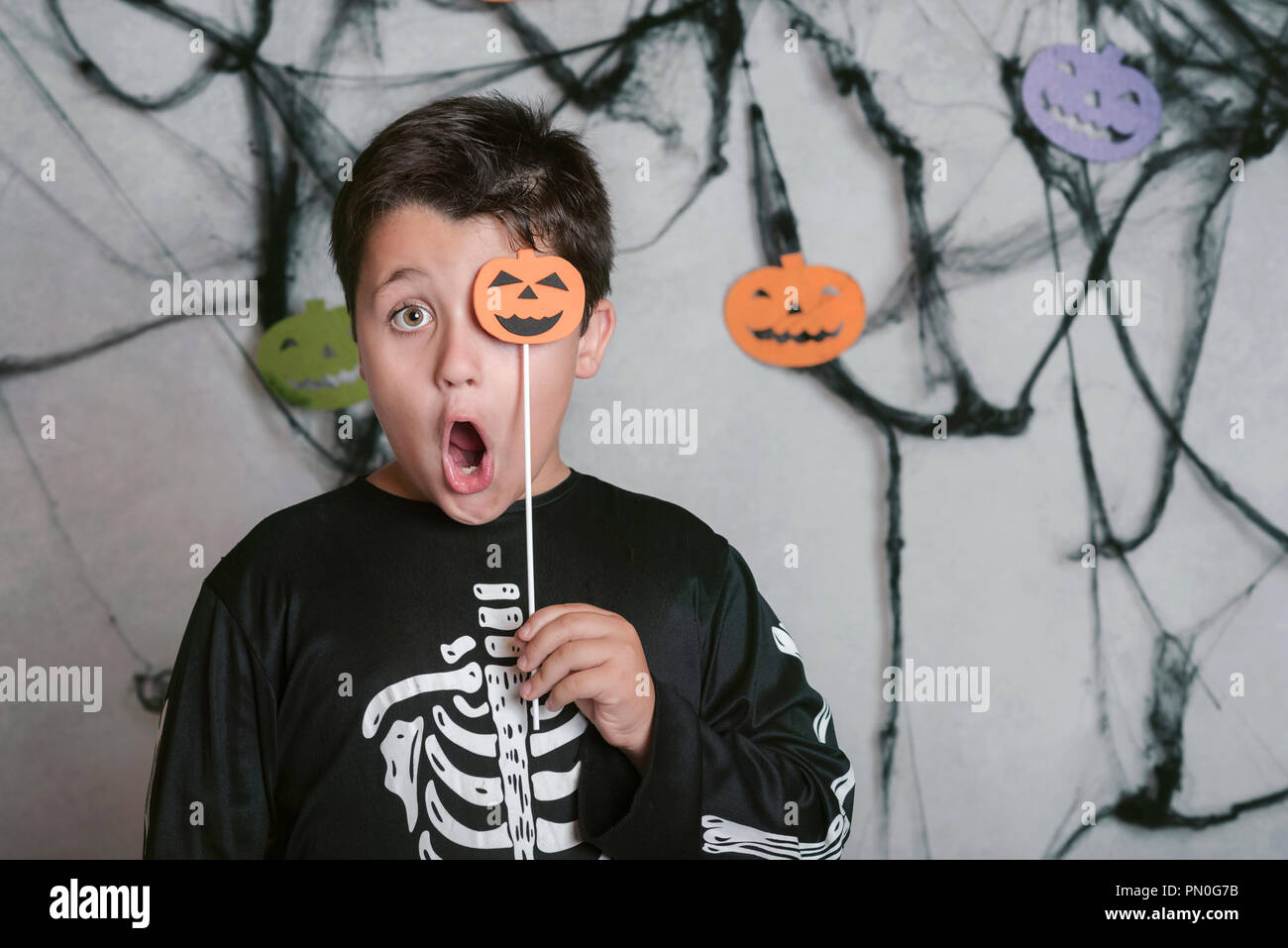 Bambino con una zucca che copre il suo occhio alla festa di Halloween Foto Stock