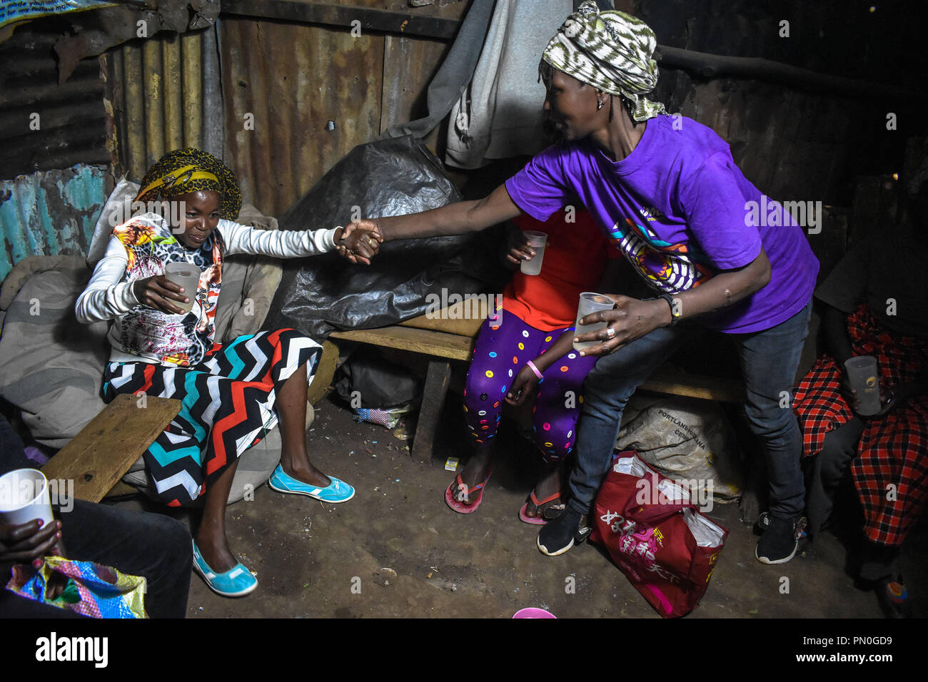 Le donne si vede l'assunzione di alcool. Le donne di Kibera baraccopoli all'età di venticinque e sopra sono la vendita di alcol per sopravvivere attraverso la loro vita quotidiana. Come molte donne potrebbero assumere alcol come un modo di celebrazione e di come un modo di collegarsi con gli amici e la famiglia durante i loro momenti di svago in uno di Nairobi bidonville Kibera, donne qui lo consumano per diversi motivi tra i quali la presa in consegna di stress e dimenticare i loro problemi familiari torna a casa. Foto Stock