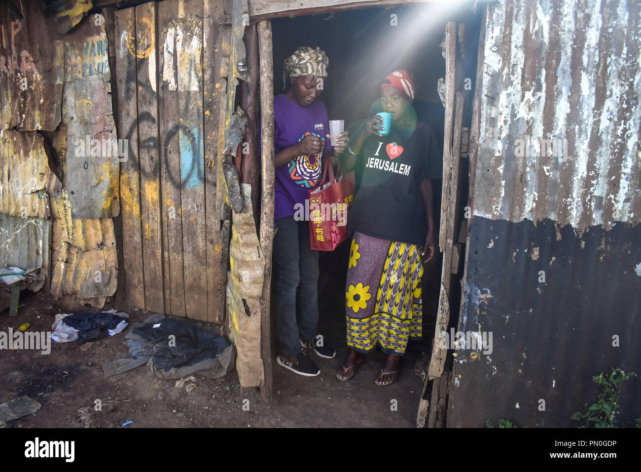 Le donne visto in piedi l'assunzione di alcool. Le donne di Kibera baraccopoli all'età di venticinque e sopra sono la vendita di alcol per sopravvivere attraverso la loro vita quotidiana. Come molte donne potrebbero assumere alcol come un modo di celebrazione e di come un modo di collegarsi con gli amici e la famiglia durante i loro momenti di svago in uno di Nairobi bidonville Kibera, donne qui lo consumano per diversi motivi tra i quali la presa in consegna di stress e dimenticare i loro problemi familiari torna a casa. Foto Stock